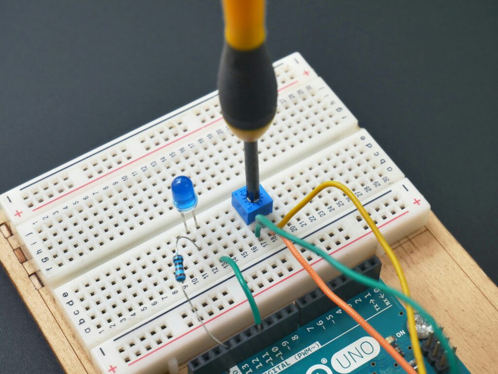A simple breadboard circuit being adjusted with a screwdriver, using an open source SBC, this symbolises that open source mindset might need some adjustment.