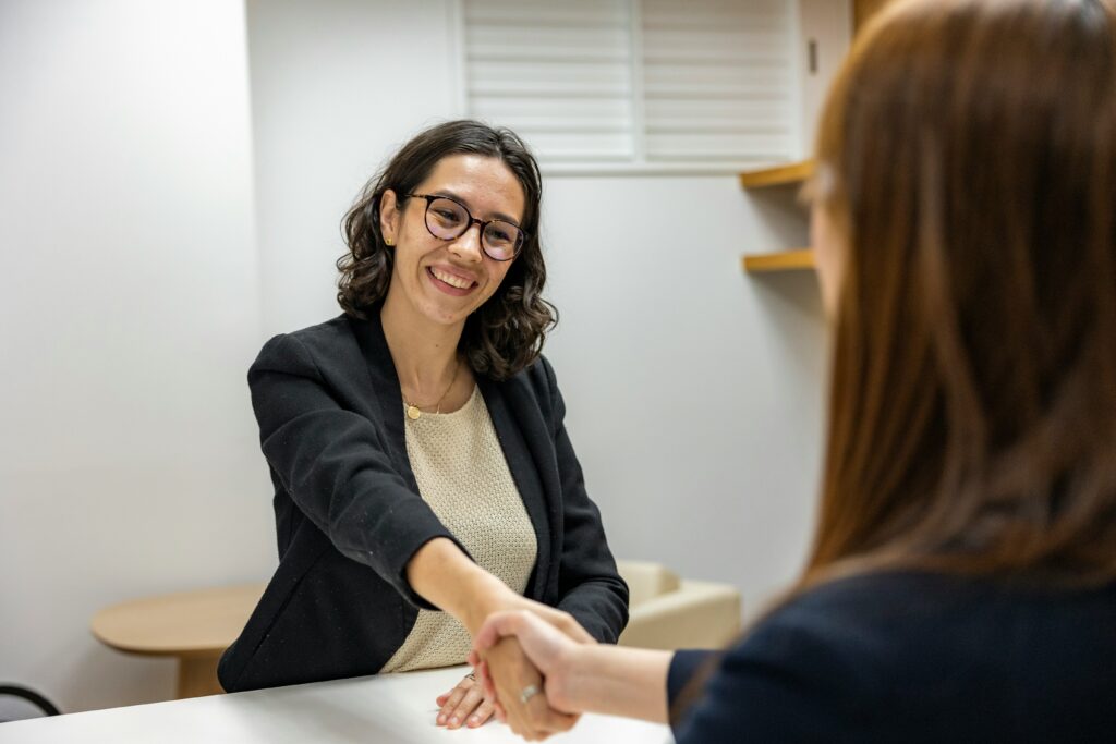 Two women shaking hands to symbolise that the quick hack guide to getting a job in the UK got them a job.